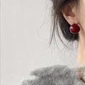Deep red cherry spherical stud earrings with glossy finish shown on model - Wine Red Round Stud Earrings