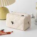 Quilted floral cosmetic bag in cream with bird embroidery and silver zipper closure - Embroidered Beige Bow