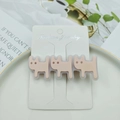 Close-up of three pink acetate cat hair clips on display card with white ceramic tray - Pink