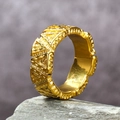 Detailed macro view of gold wide band ring with embossed geometric triangle pattern texture - Gold / US 7