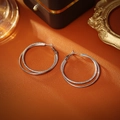 Double-layer silver hoop earrings featuring polished and frosted textures on orange leather - Silver