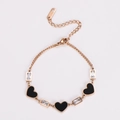 Detalle de pulsera de acero rosa con esmalte de corazón negro y piedras de circón - Oro rosa