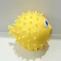 Détail macro d'un jouet pufferfish jaune à presser montrant des pointes en silicone souple - Poisson-globe Jaune