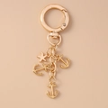 Golden alloy keychain with anchor and starfish charms on a metallic ring chain - Gold