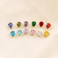 Macro detail of twelve colorful teardrop-shaped zircon pendants on silk fabric - Set of 12