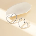 Macro detail of silver heart stud earrings with a unique textured molten lava surface finish - Heart Lava Texture / Silver