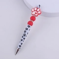 Close-up of DIY beadable pen with red cat paw silicone topper and paw print pattern - Dog Paw Red