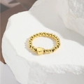 Dettaglio di un anello elastico a sfere dorate con ciondolo a cuore su sfondo pietra - Stile Ciondolo a Corona (ZYN-DMR140G-4)