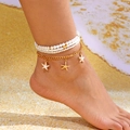 Detailed view of layered gold anklet with white pearls and starfish charms on a beach - Heart Pearl 4-Piece Set