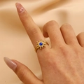 Detail of 18K gold sunburst ring featuring a centered blue oval gemstone on silk - 40 18k Pure Gold Sun 9734