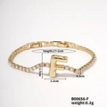Detailed view of gold letter F bracelet featuring sparkling white zircon stones and tennis chain - Letter F