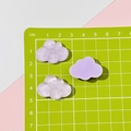 Macro shot of 3cm translucent resin cloud charms for DIY crafts on a measuring mat - Purple