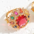Dettaglio anello placcato oro con grande zircone rosso centrale e pietre multicolore - Aperto Regolabile / Anello in zirconia rossa