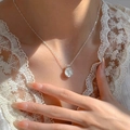 Silver-finish necklace with round rose relief pendant shown on a model - Rose Relief Style (XL2383)