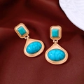 Dettaglio di orecchini vintage con turchese a goccia su tessuto di seta bordeaux - Oro-Azzurro