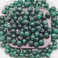 Close-up of 10mm green cracked glass beads for DIY jewelry making on a dark wood block - 8mm / Dark Green