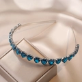 Detailed view of emerald blue heart gemstones on a silver metallic headband over silk - Royal Blue Heart Style (FG0009-14)