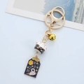 Dettaglio del portachiavi Maneki Neko in ceramica con ciondolo astronauta e campanellino - Gatto della Fortuna Nero
