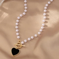 Dettaglio della collana di perle con chiusura a T dorata e ciondolo a cuore nero - Nero