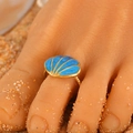 Golden shell toe ring with blue ocean enamel and spiral band on beach sand background - Blue Shell (3503) / Gold