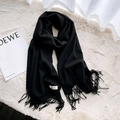 Classic black cashmere-style winter scarf with fringes and minimalist label on white rug - Black