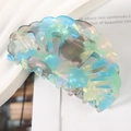 Detailed view of the shell-shaped hollow hair claw in a glossy iridescent mermaid finish - 8.2cm / Green