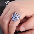Close-up of floral ring with light pink and blue flowers on a polished gold band - Adjustable Open / Eco Blue KC Gold