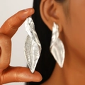 Macro detail of silver irregular leaf earrings showing brushed metal texture and folds - Brushed Abstract Leaf Shape (DZ-297) / Silver