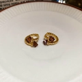 Detailed view of gold plated twisted hoop earrings featuring square brown zircon stones - Gold (18K Gold Plated)