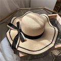 Elegant beige straw hat with black bow detail and wavy brim for sun protection - One Size / Beige