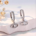 Silver hoop earrings featuring diamond-set devil's eye pendants on white stone background - Silver Evil Eye