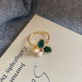 Adjustable gold ring with green stones and pearls on a vintage book background - Dark Green Butterfly Stone Pearl Ring(NL00596R-G)