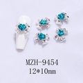 Detail of 12x10mm silver bow nail art charm with a blue heart crystal on a white nail - Silver Base Dark Blue Heart (9454)
