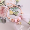 Rose gold heart charm bracelet with pink glass beads on a floral background - Pink Glass Heart Leaf Style (1#)