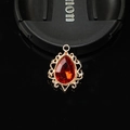 Macro shot of gold filigree teardrop pendant with a large faceted red gemstone - Red
