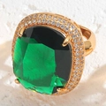Makroaufnahme eines 14K vergoldeten Rings mit quadratischem Smaragd-Edelstein und Zirkon - Rechteckiger Smaragd-Edelstein