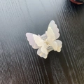 Detail of pearlescent white butterfly hair claw clip with golden metal spring - Iridescent White