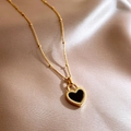 Double-sided black heart pendant necklace in gold finish on champagne silk backdrop - Necklace / Gold / Black & White Double-sided