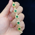 Elegant gold bracelet with square green gemstones and white diamonds on black background - Green Zircon (Gold Color)