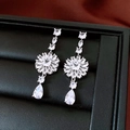 Detailansicht eleganter silberner Tropfenohrringe mit Zirkonia auf schwarzem Display - Silber