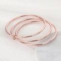 Detail of rose gold triple interlocking bangles in polished 3mm stainless steel finish - 3 Rings (All Rose Gold)