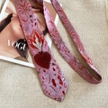 Détail d'une cravate brodée rose avec motif cœur sacré et œil sur tissu en soie - Style de Cravate à Imprimé Sacré-Cœur / Rouge