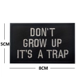 Rechteckiger Stickpatch DON'T GROW UP IT'S A TRAP mit weißem Text auf schwarzem Grund - DON'T GROW UP IT'S A TRAP / Schwarz und Cremeweiß