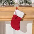 Red knit Christmas stocking with white faux fur cuff and dual pompoms on a wooden mantel - Red