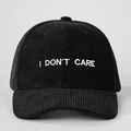 Λεπτομέρεια του λευκού κεντήματος I DON'T CARE στο μαύρο κοτλέ καπέλο του μπέιζμπολ - Ρυθμιζόμενο / Μαύρο