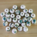 Macro shot of white ceramic beads with cyan and purple floral patterns on wood - No.40-Blue Purple Floral