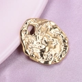 Macro shot van onregelmatige gouden hanger met gehamerde textuur van 304 roestvrij staal - Goud