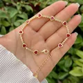 Detail of 18K gold heart bracelet with red rubies and cubic zirconia accents - Red