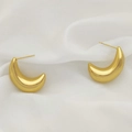 Macro detail of thick gold-plated U-shaped crescent earrings on soft white silk fabric - Bold Crescent Style (XL1464-36)