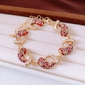Macro di bracciale dorato con smalto rosso e strass in una scatola di velluto per gioielli - Bracciale-Oro-Rosso